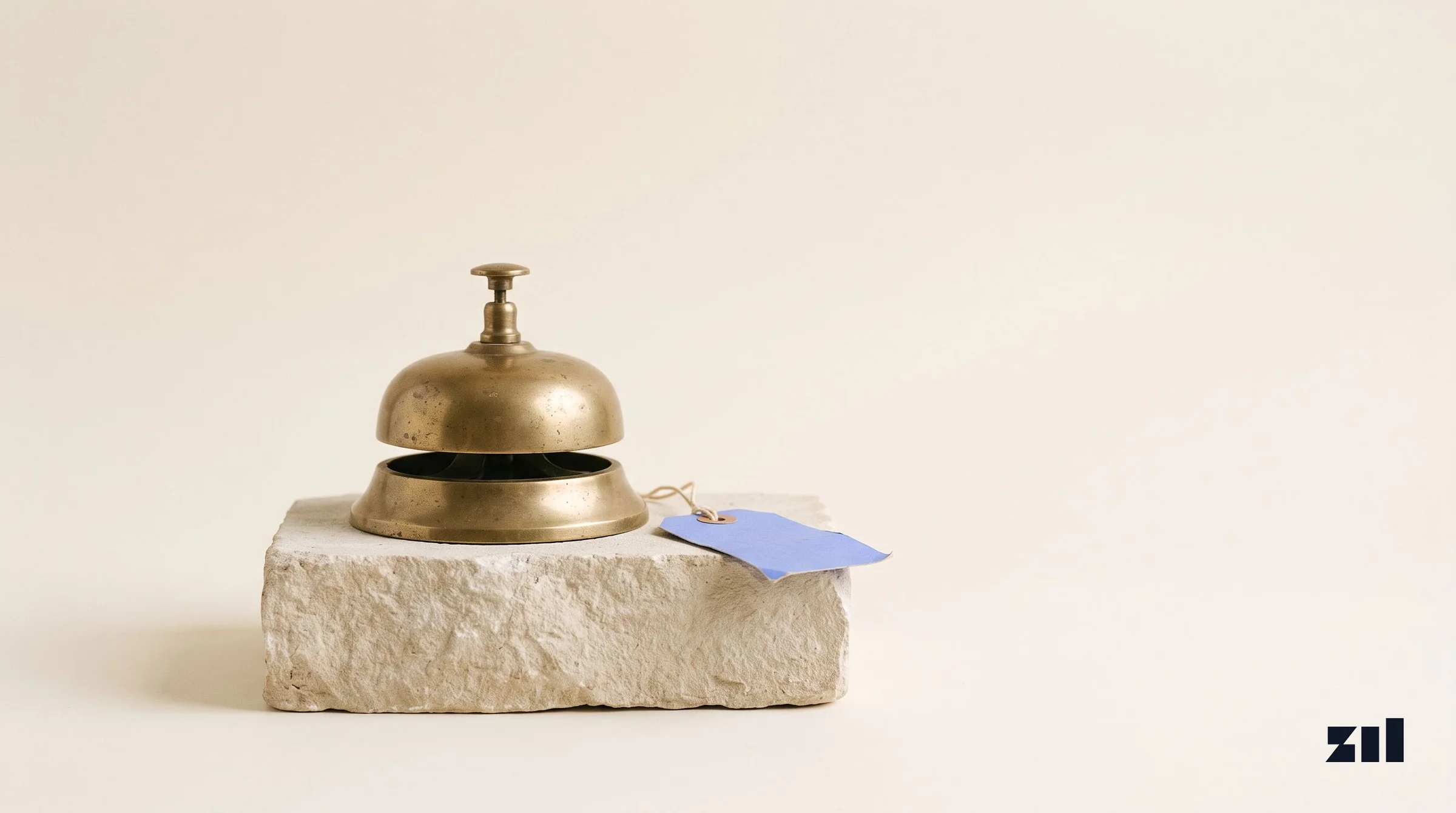 Campana de escritorio vintage sobre piedra, ilustrando el impacto de los resúmenes de IA.